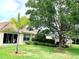 Beautiful backyard with a patio, lush green lawn, and a variety of trees and shrubs at 7649 Quinto Dr, Sarasota, FL 34238