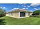 This is a lush, green backyard featuring a sliding glass door, a spacious lawn, and a cozy outdoor living space at 7649 Quinto Dr, Sarasota, FL 34238