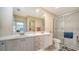 Bright bathroom with double sinks, a large mirror, and a glass-enclosed shower with neutral tiling at 7649 Quinto Dr, Sarasota, FL 34238