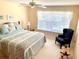 Bedroom featuring a queen-sized bed, ceiling fan, and a comfy chair with a natural view from the window at 7649 Quinto Dr, Sarasota, FL 34238
