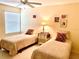 Bedroom featuring twin beds with decorative pillows and matching wooden night stands at 7649 Quinto Dr, Sarasota, FL 34238