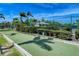 Outdoor bocce court features well maintained hedges, palm trees, and a covered structure, all on a sunny day at 7649 Quinto Dr, Sarasota, FL 34238