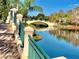 Scenic view of a charming bridge over a serene lake, surrounded by lush landscaping at 7649 Quinto Dr, Sarasota, FL 34238