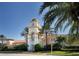 This is a Town Center clubhouse with a clock tower, manicured landscaping, and palm trees creating a welcoming environment at 7649 Quinto Dr, Sarasota, FL 34238
