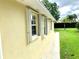 Side exterior view shows the home's protective shutters and a well-maintained lawn with green landscaping at 7649 Quinto Dr, Sarasota, FL 34238