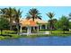Lakeside gazebo with lush landscaping and palm trees, offering a serene outdoor space at 7649 Quinto Dr, Sarasota, FL 34238