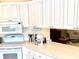 Modern kitchen with white cabinets, a peninsula counter, and stainless steel appliances overlooking the living area at 7649 Quinto Dr, Sarasota, FL 34238