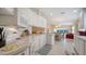 Bright kitchen featuring white cabinetry and stainless steel microwave overlooking the adjacent dining and living areas at 7649 Quinto Dr, Sarasota, FL 34238