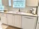Bright kitchen with white cabinets, a large window, and modern appliances for a clean and efficient cooking space at 7649 Quinto Dr, Sarasota, FL 34238