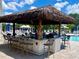 Inviting poolside bar with shaded seating and tropical decor, perfect for relaxing and enjoying refreshing beverages at 7649 Quinto Dr, Sarasota, FL 34238