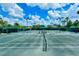 Community tennis court featuring well-maintained surface and lighting for nighttime play at 7649 Quinto Dr, Sarasota, FL 34238