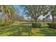 A serene backyard view featuring a tranquil pond surrounded by lush green grass and mature trees, creating a peaceful oasis at 8300 Jesolo Ln, Sarasota, FL 34238