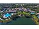 Aerial view of a community clubhouse, pools, and amenities surrounded by a lake and lush landscaping at 8300 Jesolo Ln, Sarasota, FL 34238