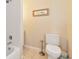 Bathroom with white tile, a toilet, and a framed print at 8404 43Rd W Ave, Bradenton, FL 34209