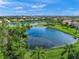 Scenic aerial view of a residential community featuring lush greenery, a lake, and well-maintained homes at 8956 Stone Harbour Loop, Bradenton, FL 34212