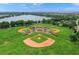 Aerial view of baseball fields surrounded by lush green space and a scenic lake in the background at 8956 Stone Harbour Loop, Bradenton, FL 34212