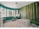 Green Bedroom with wallpapered forest scene, crib, and ceiling fan at 8956 Stone Harbour Loop, Bradenton, FL 34212