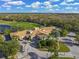 An aerial view of the stunning clubhouse, meticulously landscaped with palm trees and elegant entrance at 8956 Stone Harbour Loop, Bradenton, FL 34212