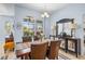 Dining room with a wooden table, leather chairs, and a large window overlooking the greenery at 8956 Stone Harbour Loop, Bradenton, FL 34212