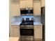 Stainless steel stove and microwave with white cabinets are showcased in this kitchen at 8956 Stone Harbour Loop, Bradenton, FL 34212