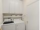 Functional laundry room with white cabinetry, shelving, front loading washer and dryer, and neutral walls at 8956 Stone Harbour Loop, Bradenton, FL 34212