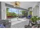 Covered patio with ceiling fans, an outdoor dining table, wicker furniture, and views of a lake at 8956 Stone Harbour Loop, Bradenton, FL 34212