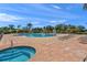 Community pool and hot tub with brick patio, lounge chairs, and blue sky in the background at 8956 Stone Harbour Loop, Bradenton, FL 34212