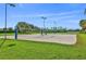 Sandy volleyball court in a community setting with lush green grass and a lake at 8956 Stone Harbour Loop, Bradenton, FL 34212