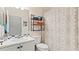 Well-lit bathroom featuring a shower with patterned curtains, a vanity, and decorative storage shelves at 914 Regal Manor Way, Sun City Center, FL 33573