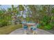 Seating area with a table and chairs, providing a peaceful spot along the waterfront with tropical foliage at 940 Siesta Key Pl, Sarasota, FL 34242