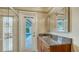 Well-lit bathroom with granite countertop vanity, walk-in shower and convenient access door to backyard pool at 940 Siesta Key Pl, Sarasota, FL 34242