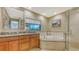Well-lit bathroom with a large window, double sinks, a soaking tub, and a glass-enclosed shower at 940 Siesta Key Pl, Sarasota, FL 34242