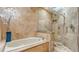 Luxurious bathroom with a soaking tub, walk-in shower featuring marble surround and an elegant plant at 940 Siesta Key Pl, Sarasota, FL 34242
