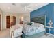 Elegant bedroom featuring a patterned ceiling, blue accent wall, and upholstered headboard at 940 Siesta Key Pl, Sarasota, FL 34242