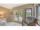 Relaxing bedroom featuring a chair, dresser, and views of the outdoors through the French doors at 940 Siesta Key Pl, Sarasota, FL 34242