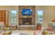 Beautiful stone fireplace with a mounted TV and windows providing views of the surrounding landscape at 940 Siesta Key Pl, Sarasota, FL 34242