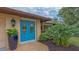 Close-up of the entry showing a bright blue door with oval glass inserts, adding a pop of color at 940 Siesta Key Pl, Sarasota, FL 34242