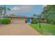 Charming home with a well-manicured lawn, lush landscaping, and a welcoming blue front door at 940 Siesta Key Pl, Sarasota, FL 34242