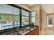 Kitchen sink with black granite countertop and a large window overlooking the pool and backyard at 940 Siesta Key Pl, Sarasota, FL 34242