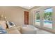 Cozy living area with a white leather ottoman and access to an outdoor pool area through glass doors at 940 Siesta Key Pl, Sarasota, FL 34242