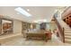 Open-concept living room with stone fireplace, skylights, staircase, and tile flooring throughout at 940 Siesta Key Pl, Sarasota, FL 34242