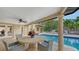 Covered patio with dining set overlooking the refreshing swimming pool and backyard at 940 Siesta Key Pl, Sarasota, FL 34242