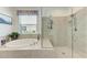 Bathroom showcasing a soaking tub with jets and a glass-enclosed shower at 10010 Buckman Halls Dr, Palmetto, FL 34221