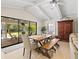 Bright dining room with large windows looking out onto lanai and backyard featuring a farmhouse table with bench seating at 1231 Quail Run Trl, Sarasota, FL 34232