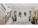 Bright foyer features a staircase, decorative tile floor, and a view to the front yard through glass doors at 1231 Quail Run Trl, Sarasota, FL 34232