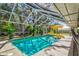 Screened in pool with cool blue water, outdoor plants and umbrella offers a relaxing outdoor oasis at 1231 Quail Run Trl, Sarasota, FL 34232