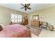 Bright bedroom with a ceiling fan, tile floor, and windows with shutter style blinds at 12343 Halfmoon Lake Ter, Bradenton, FL 34211