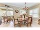 Elegant dining room with a chandelier, wooden table, and access to a screened lanai at 12343 Halfmoon Lake Ter, Bradenton, FL 34211