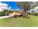 Landscaped front yard featuring mature tree and colorful shrubbery at 12343 Halfmoon Lake Ter, Bradenton, FL 34211