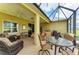 Relaxing screened-in patio with stylish wicker furniture, ceiling fan, and outdoor grill for enjoyable outdoor living at 12343 Halfmoon Lake Ter, Bradenton, FL 34211